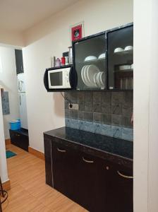 una cocina con microondas en la parte superior de un armario en Esses House A Luxury Homestay and service apartment en Gangtok