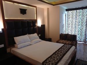 Un dormitorio con una cama y una silla y una ventana. en Esses House A Luxury Homestay and service apartment, en Gangtok