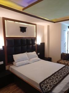 Un dormitorio con una cama grande con cabecero negro. en Esses House A Luxury Homestay and service apartment, en Gangtok