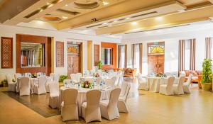 a banquet hall with white tables and white chairs at Charmillion Sea Life Resort in Sharm El Sheikh