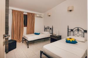 a hotel room with two beds and a window at Villa Andriana & Villa Elena - Beachfront Pool Villas in Vasilikos +57 photos