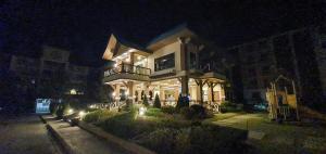 un gran edificio por la noche con luces en Summer10th Pinesuites Scandi Minimalist Deluxe, en Tagaytay