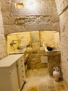 a stone bathroom with a sink and a toilet at Trulli Antichi Mestieri - Widespread Trulli in the historic center in Alberobello