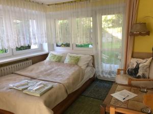Schlafzimmer mit einem Bett mit einem Tisch und Fenstern in der Unterkunft Azyl Karpacz in Karpacz