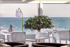 stół z białymi krzesłami i widokiem na ocean w obiekcie UnderSun Spa Hotel w mieście Hrybiwka