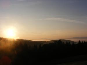 un tramonto tra le montagne con il sole all'orizzonte di Stare Sioło a Wysokie