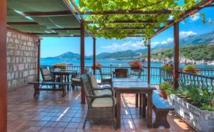 a patio with tables and chairs and a view of the water at Apartments Porat in Sveti Stefan