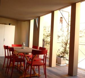 ein Esszimmer mit einem Holztisch und roten Stühlen in der Unterkunft Lanfranchi deluxe apartament in Pisa