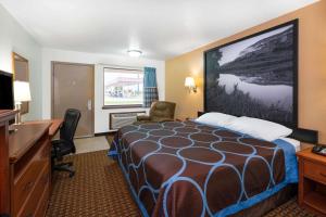 a hotel room with a bed and a desk at Super 8 by Wyndham Goodland in Goodland
