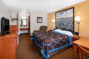 a hotel room with a bed and a flat screen tv at Super 8 by Wyndham Goodland in Goodland