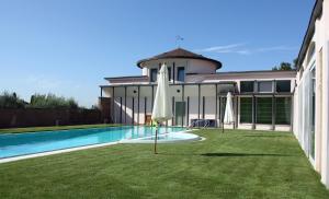 ein Haus mit Pool und Rasen in der Unterkunft Villa bright and quiet 45 from the center of Rome, private pool exclusively in Sermoneta