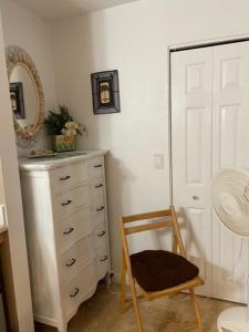 a chair in a room with a dresser and a mirror at Kalama Room in Kailua
