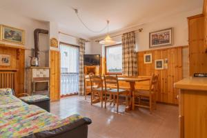 a kitchen and dining room with a table and chairs at Condominio Le Coste in Falcade