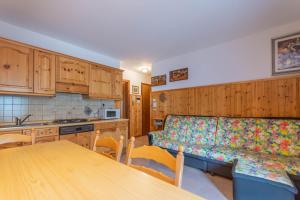 a kitchen with a couch and a table in it at Condominio Le Coste in Falcade +13 photos