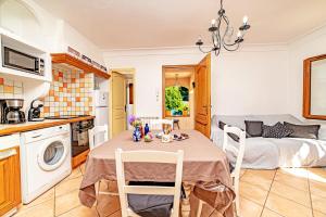 cocina y sala de estar con mesa y sillas en Holidays In Provence Alpes Maritimes, en Le Bar-sur-Loup