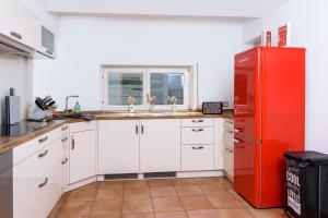 a kitchen with a red refrigerator and a sink at Berg Fux - Zwei Ferienhäuser mit je 5 und 6 Schlafzimmern mit eigener Dachterrasse - fantastischem Bergblick - Weber Gas Grill in Sonthofen