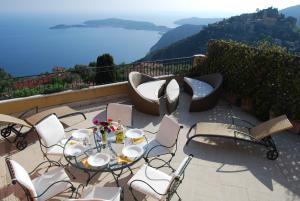 un patio con tavolo e sedie con vista di Stunning Penthouse with panoramic views of Eze Village and the French Riviera a Èze