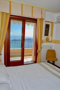 una camera da letto con un letto e vista sull'oceano di Stunning Penthouse with panoramic views of Eze Village and the French Riviera a Èze