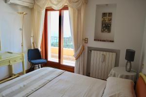 una camera da letto con un letto, una finestra e una sedia di Stunning Penthouse with panoramic views of Eze Village and the French Riviera a Èze Altre 21 foto