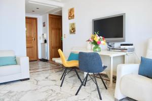 un soggiorno con scrivania, TV e sedie di Stunning Penthouse with panoramic views of Eze Village and the French Riviera a Èze