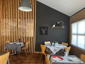 a dining room with two tables and a window at Hotel Aragón in Puebla de Alfindén