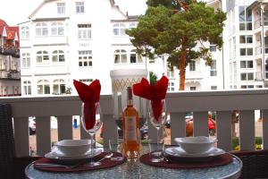 einen Tisch mit einer Flasche Wein und Gläsern auf dem Balkon in der Unterkunft Residenz an der Prorer Wiek Ferienwohnung 09 in Binz