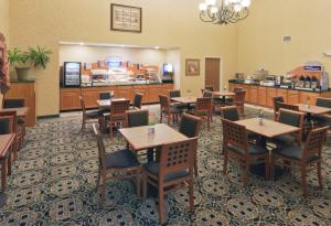 a dining room with tables and chairs in a restaurant at Holiday Inn Express Hotel & Suites Pierre-Fort Pierre by IHG in Fort Pierre
