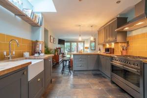 a large kitchen with gray cabinets and a sink at Lovely Central Cambridge Home in Cambridge