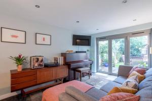 a living room with a couch and a piano at Lovely Central Cambridge Home in Cambridge