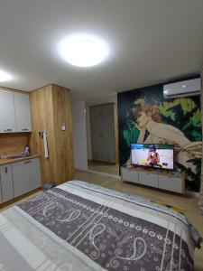 1 dormitorio con 1 cama grande y una pintura en la pared en Intime by Nights & Smiles en Tuzla