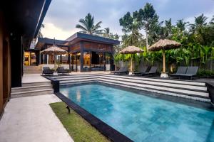 ein Swimmingpool vor einem Haus in der Unterkunft Villa Singa by BaliSuperHost in Ubud