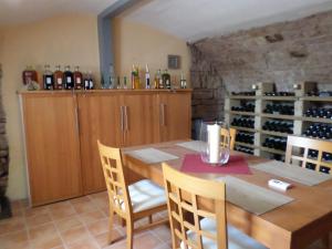 Villa Geisenhof في ميلتينبرغ: غرفة طعام مع طاولة وبعض زجاجات النبيذ