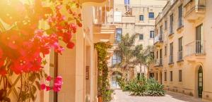 an empty street in a city with pink flowers at Holiday Hub Gozo - 3 Bedrooms in Xewkija