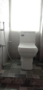 - białą toaletę w łazience z prysznicem w obiekcie RISE N SHINE HOMESTAY w mieście Dardżyling