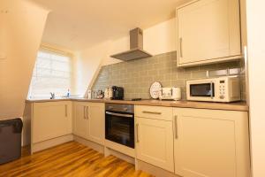 kuchnia z białymi szafkami i białymi urządzeniami w obiekcie Stylish City Apartment - Prime Location! w Nottingham