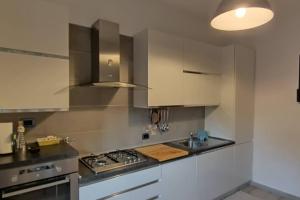 a kitchen with white cabinets and a stove and a sink at Appartamento di Zeno in Rome