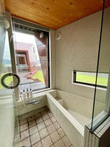 a bathroom with a shower and a sink and a window at Seaside SHELL HOUSE -南房総 海辺のSHELL HOUSE- in Minamiboso