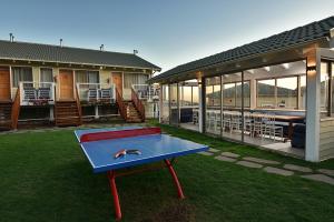 una mesa de ping pong en el patio de una casa en White Suites, en Majdal Shams