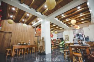 a restaurant with wooden ceilings and wooden tables and chairs at Gaodiyuan Tea B&B 高帝園茶業民宿 in Meishan