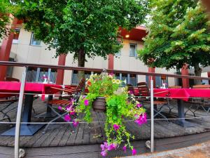 a table and chairs with flowers on a patio at Hotel Prunk in Sežana