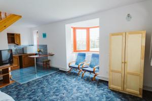 a living room with two chairs and a kitchen at Janka Villa in Călugăreni