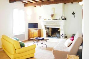 a living room with a yellow couch and a fireplace at Ménerbes Home with Private Pool in Ménerbes