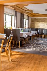 a dining room with tables and chairs on a carpet at Hotel Lang in Breidenbach