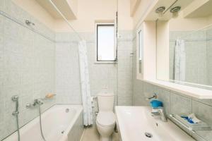 a bathroom with a toilet and a tub and a sink at Apartment in Chania with outdoor pool in Chania