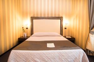 1 dormitorio con 1 cama grande y 2 mesitas de noche en Domus RomAntica en Roma