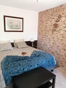 ein Schlafzimmer mit einem Bett und einer Ziegelwand in der Unterkunft Varandas da Serra in Vila Franca de Xira