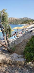 Eine Gruppe von Menschen, die unter Sonnenschirmen am Strand liegen in der Unterkunft Iason Hotel Apartments in Giosonas