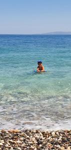 ein Mann im Wasser im Ozean in der Unterkunft Iason Hotel Apartments in Giosonas + 44 Fotos