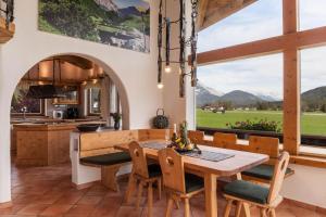 une cuisine et une salle à manger avec une table et des chaises dans l'établissement Panorama Lodge Leutasch mit Sauna, à Leutasch