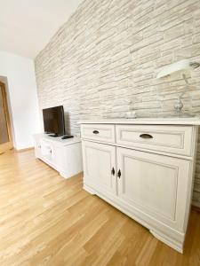 a kitchen with a white cabinet and a wall at Apartment Evelina in Pula
